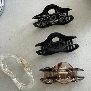 Close-up of set of four hair claw clips in black, clear and amber tortoiseshell finish