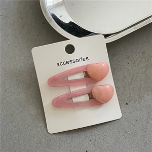 Close-up of pink jelly resin heart hair clips on a white accessories display card