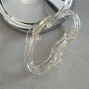 Close-up of transparent wavy hair claw clip showing internal golden metal spring detail