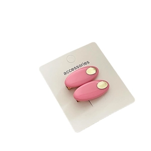 Lot de deux barrettes ovales roses avec accents en métal doré sur carte de présentation