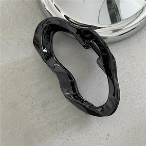 Close-up of black glossy wave claw clip with a strong metal spring mechanism