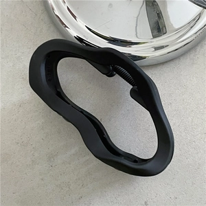 Close-up of matte black large hair claw clip with organic wavy texture and metal spring