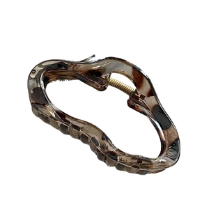 Elegant amber leopard print hair claw clip with a wavy resin cloud shape and gold spring