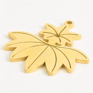 Detailed macro view of a 304 stainless steel golden maple leaf charm for DIY jewelry