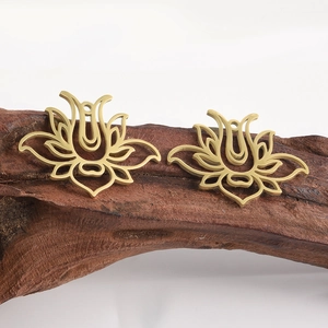 Pair of hollow lotus flower pendants in matte gold stainless steel on driftwood