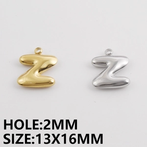 Detailopname van de letter Z hanger in goud en zilver met een puffy bol ontwerp