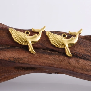 Détail macro de deux pendentifs baleine en plaqué or 18k pour la création de bijoux