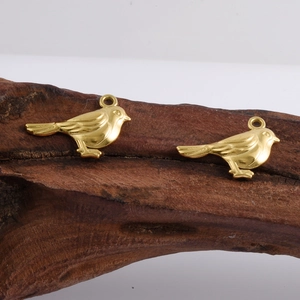 Pair of 18k gold plated 304 stainless steel bird pendants on rustic wood background