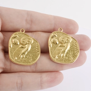 Hand holding vintage 18k gold plated 304 stainless steel owl coin pendants