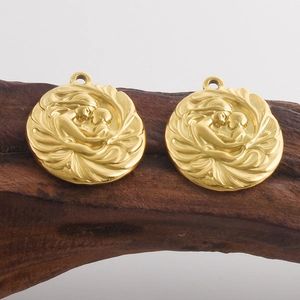 Détail du pendentif vintage doré avec relief mère et enfant sur fond de bois