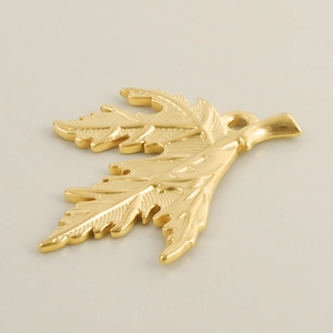 Detailed close-up of a matte gold-plated leaf pendant with intricate vein textures