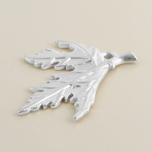Macro detail of leaf-shaped stainless steel pendant with natural vein texture engraving