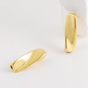 Macro-opname van gouden gedraaide metalen kralen met gaten voor DIY-sieraden maken