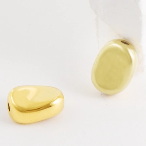 Detailweergave van gouden onregelmatige kralen met gepolijste spiegelafwerking voor sieraden
