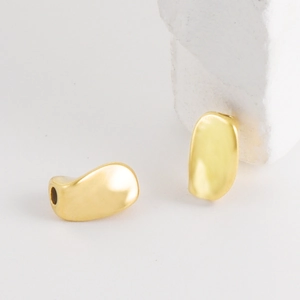 Macro-opname van twee onregelmatige gouden organische bonen van rvs 304 voor DIY-sieraden maken