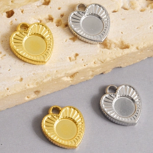 Detail van hartvormige roestvrijstalen hangers met zonnestraalmotief voor DIY-sieraden