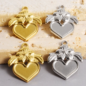 Vue macro de pendentifs floraux en forme de cœur dorés et argentés sur une pierre texturée