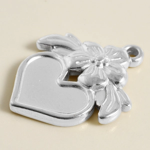Vue macro détaillée d'un pendentif coeur en acier inoxydable 304 avec relief floral gravé
