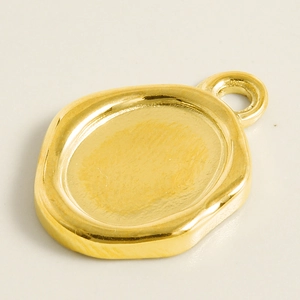 Vue détaillée d'un pendentif ovale irrégulier en acier doré de style sceau de cire