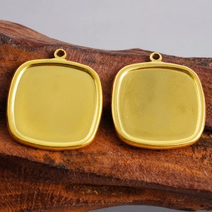 Primer plano de colgantes cuadrados de acero inoxidable dorado sobre madera oscura