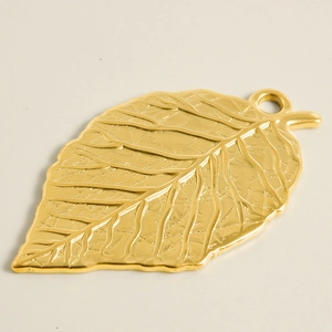 Macro shot of gold leaf pendant showing realistic vein textures and polished metal finish