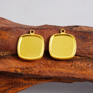Detalle de bases de colgante cuadradas en acero dorado sobre madera natural para joyería DIY