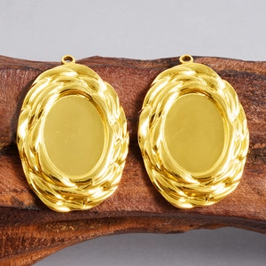 Close-up of golden oval 304 stainless steel pendant bases with twisted rope texture edge
