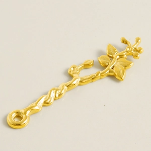 Macro detail of a 304 stainless steel gold branch pendant with twisted leaf texture