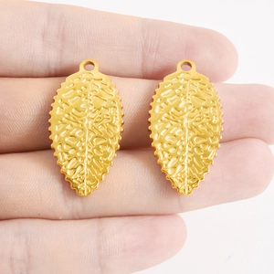 Détail de pendentifs feuille dorés avec veines fines et finition polie pour bijoux DIY