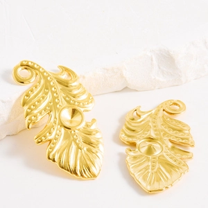 Détail de pendentifs plume dorée avec finition mate pour la création de bijoux DIY