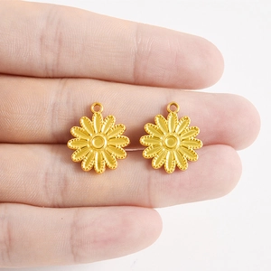Gros plan de pendentifs fleur dorés en acier 304 montrant les détails et la taille