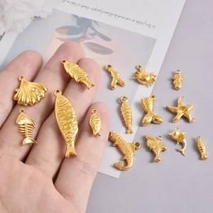 Pendentifs marins en acier inoxydable 304 doré pour bijoux DIY présentés sur la main