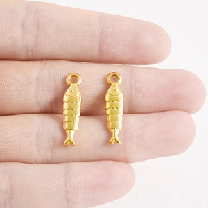 Vue détaillée de deux pendentifs poissons dorés avec écailles pour bijoux DIY