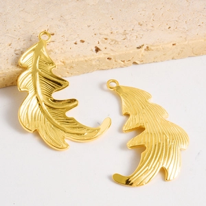 Détails de pendentifs feuilles dorées avec textures de veines et finition en acier