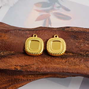 Close-up of golden square pendant bases with twisted rope edges on wooden stand
