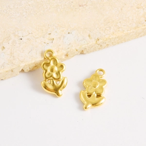 Vue détaillée de breloques fleurs dorées au fini mat pour la création de bijoux