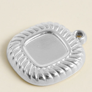 Detailed macro view of silver stainless steel square pendant base with vertical texture