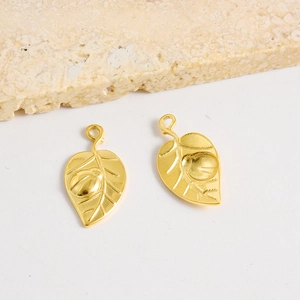Vue détaillée d'un pendentif feuille dorée avec relief coccinelle pour bijoux DIY
