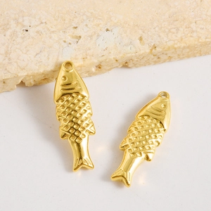 Détail macro de deux breloques poissons dorés avec écailles pour bijoux DIY