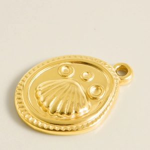 Detailed macro view of 18k gold plated stainless steel shell pendant with beaded edges