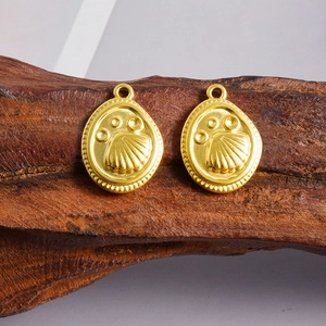 Detailed macro view of 18k gold plated shell paw pendant on dark wood texture