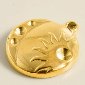 Detail of 18k gold plated stainless steel sun and moon embossed circular pendant charm