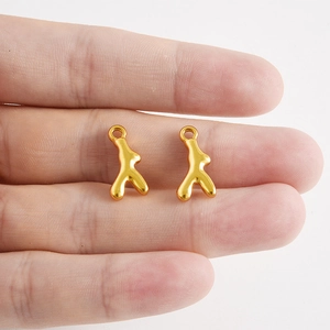 Gros plan de pendentifs en forme de corail doré en acier inoxydable pour bijoux DIY