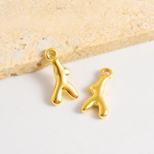Vue macro de pendentifs corail en acier inoxydable doré avec finition polie brillante