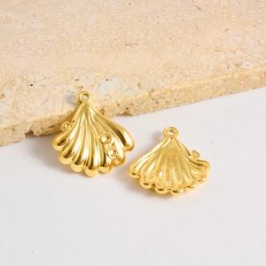 Gros plan de pendentifs coquillages dorés montrant la texture et les fentes d'incrustation