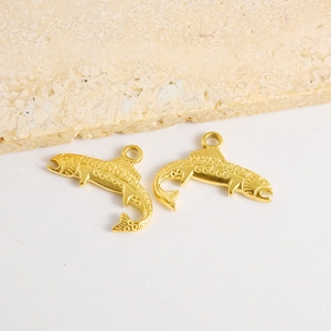 Vue détaillée d'un pendentif poisson doré avec texture en relief sur fond de pierre