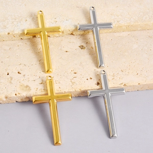 Detailed macro view of 304 stainless steel cross pendants in gold and silver finishes