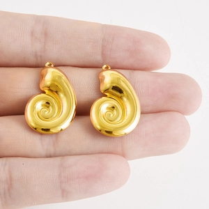 Dettaglio dei ciondoli a conchiglia a spirale placcati oro 18k per creazione gioielli