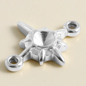 Macro view of silver eight-pointed star connector with dual hooks for jewelry making