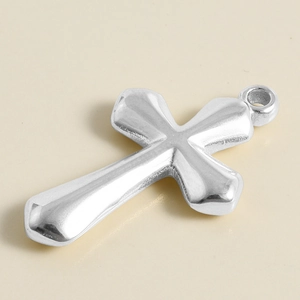 Macro shot of a silver stainless steel cross pendant with high polished metallic finish